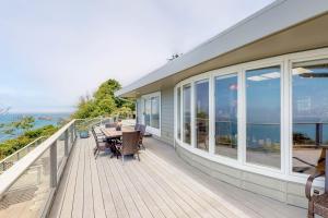 a house with a deck with a table and chairs at Whalerock Luxury Home in Trinidad