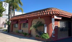 un pequeño edificio rojo al lado de una calle en Uptown Inn en Long Beach