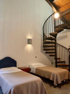 a room with two beds and a spiral staircase at Hotel Riverside in Modena