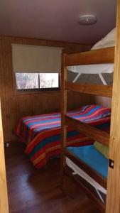 a room with two bunk beds and a window at Cabañas Tela in Lonquimay