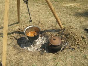 una olla de comida sentada encima de un fuego en Camp Tomasevic en Guča