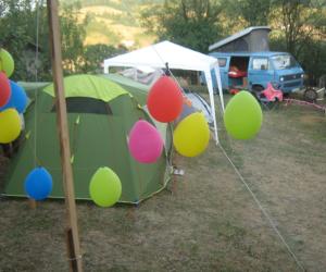 une tente verte avec des ballons devant elle dans l'établissement Camp Tomasevic, à Guča