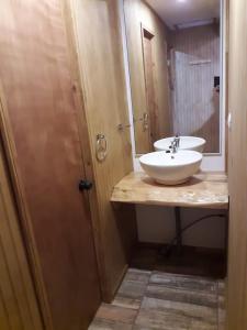 a bathroom with a white sink and a mirror at Cabañas Tela in Lonquimay
