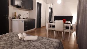 Azzano San PaoloにあるCasa Leonardo Airportのベッド1台付きの部屋、テーブル付きのキッチンが備わる客室です。