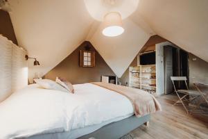 een slaapkamer met een groot bed op zolder bij Scandinave - In the Woods in Gesves