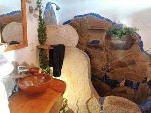 Hostal Las Olas في كوباكابانا: غرفة مع جدار حجري ووعاء على طاولة