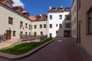 an alley between two white buildings with a grass yard at Brand new flat heart of Vilnius in Vilnius