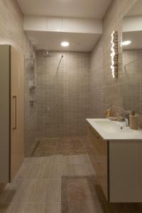 La salle de bains est pourvue d'une douche, d'un lavabo et d'une baignoire. dans l'établissement Brand new flat heart of Vilnius, à Vilnius