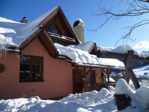 dom pokryty śniegiem i śniegiem na dachu w obiekcie Ubytovanie na briežku w mieście Mlynky 