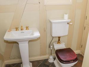 a bathroom with a white sink and a toilet at Swiss Cottage in Mohill
