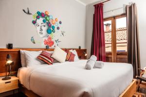 a bedroom with a bed and a painting on the wall at Selina Plaza De Armas Cusco in Cusco