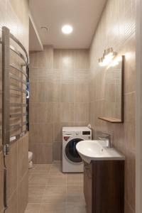 La salle de bains est pourvue d'un lave-linge et d'un lavabo. dans l'établissement Brand new flat heart of Vilnius, à Vilnius