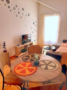 sala de estar con mesa, sillas y TV en Apartman Centar en Veliko Gradište