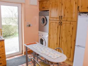 a kitchen with a table and a washer and dryer at Ellen's Cottage in Mountcharles