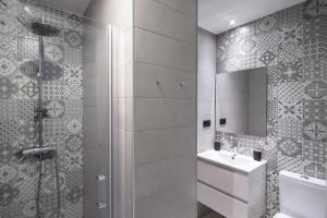 格拉纳达Granadi Apartamentos的带淋浴和水槽的浴室