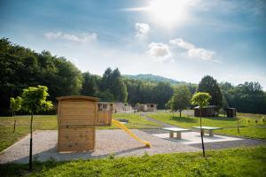 einen Park mit Spielplatz mit Rutsche und Bank in der Unterkunft Glamping Krone Kolpa Heaven in Adlešiči