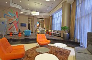 eine Hotellobby mit orangefarbenen Stühlen und Tischen in der Unterkunft Novotel Panama City in Panama-Stadt