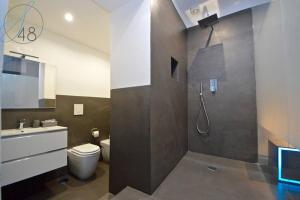e bagno con doccia, servizi igienici e lavandino. di Suite Quarantotto Luxury House a Napoli