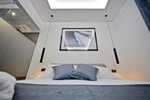 ein Bett mit zwei blauen Kissen in einem Zimmer in der Unterkunft Suite Quarantotto Luxury House in Neapel
