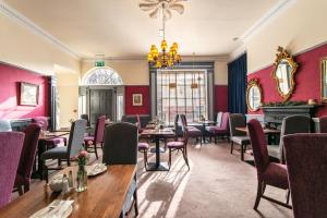 un restaurante con mesas y sillas y una lámpara de araña en Castle Hotel, en Dublín
