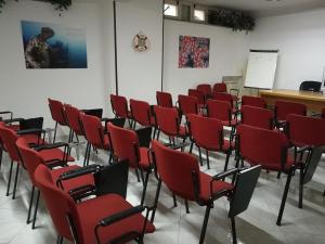 Zimmer mit roten Stühlen, einem Tisch und einem Brett in der Unterkunft Hotel La Tripergola in Pozzuoli