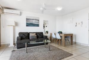 a living room with a couch and a table at Sandcastles Mooloolaba in Mooloolaba