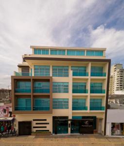 ein hohes Gebäude mit blauen Fenstern in einer Stadt in der Unterkunft Hotel Santorini Loft in Montería