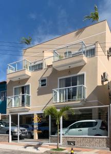 a building with cars parked in front of it at Pousada Arraial Tropical in Arraial do Cabo