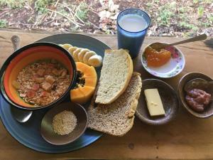 un plato de comida con un tazón de sopa y pan en Little Nomads eco-guesthouse en Siquijor