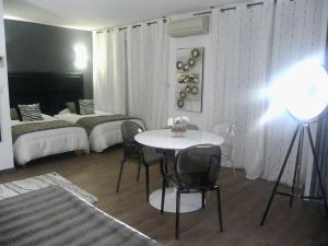 a room with a table and chairs and a bed at Hôtel Spunta Di Mare in Ajaccio