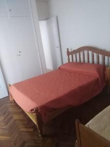 a bed with a red comforter in a room at Departamento céntrico Tupungato in Tupungato