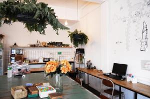 a kitchen with a table with a vase of flowers at Green Sleep Hostel in Chiang Mai