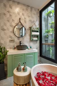 a bathroom with a sink and a tub with a mirror at Paddy Boutique House Hoian in Hoi An