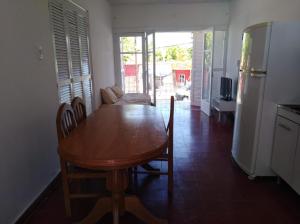 cocina y comedor con mesa de madera y sillas en Departamento céntrico Tupungato en Tupungato