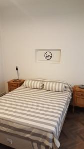1 dormitorio con 1 cama con edredón a rayas en Qatrica en Mar del Plata
