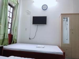 a room with a bed and a tv on the wall at Homestay Minh Nguyên in Hue