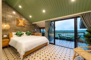 een slaapkamer met een groot bed en een balkon bij Paddy Boutique House Hoian in Hội An