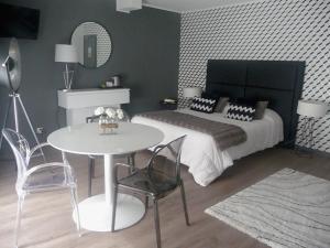 a bedroom with a bed and a table and chairs at Hôtel Spunta Di Mare in Ajaccio