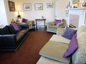 a living room with couches and a fireplace at Mackenzie House in Kirkcudbright