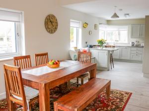 uma cozinha e sala de jantar com uma mesa de madeira e cadeiras em River Dale em Willsborough