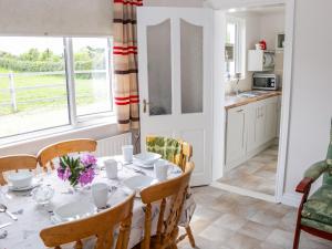 a kitchen and dining room with a table and chairs at Kate's Cottage in Ballina