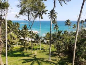 Blick auf das Meer von einem Resort mit Palmen in der Unterkunft Star Beach Hotel in Tangalle