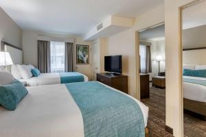 a hotel room with two beds and a flat screen tv at Franklin Extended Stay Hotel in Franklin