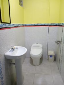 y baño con aseo y lavamanos. en Hotel ARKONA, en Huancayo