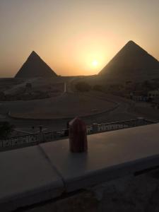 uma vista para uma estrada com duas pirâmides ao fundo em Arabian Nights Pyramids Guesthouse no Cairo