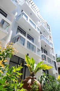 a white building with plants in front of it at Luxx Boutique Boracay in Boracay