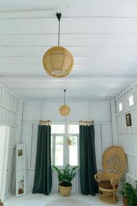 a room with green curtains and two chandeliers at One Chan Farmstay in Chanthaburi