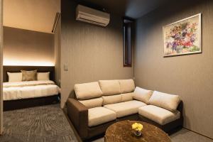 a living room with a couch and a bed at GRAND BASE Haruyoshi in Fukuoka