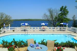 a swimming pool with chairs and a table and the water at Silver Birches Resort in Hawley