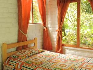 ein Schlafzimmer mit einem Bett und zwei Fenstern in der Unterkunft La Casta in Patate
